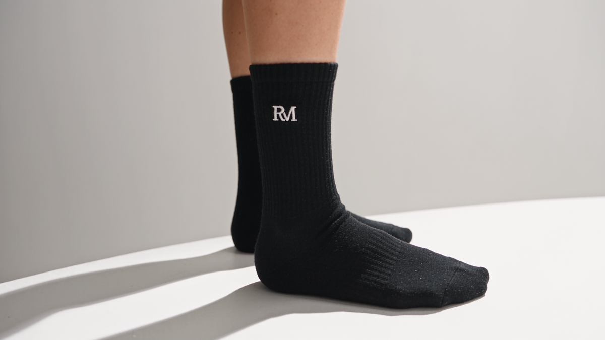 Schwarze Tennissocke mit gesticktem RM-Monogramm am Model